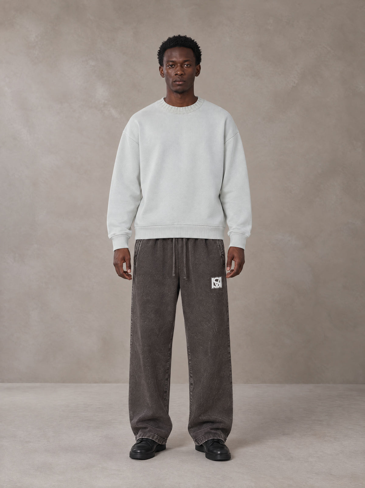 Model wearing SM Snow Fade Sweatpants in Graphite, front view.
