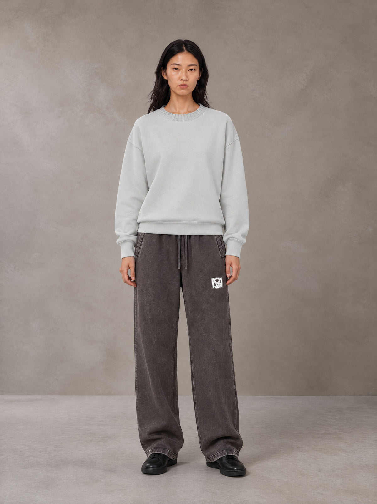 Model wearing SM Snow Fade Sweatpants in Graphite, front view.
