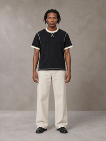 Model wearing SM Sig. Contrast Stitch T-shirt in Midnight Black, front view.