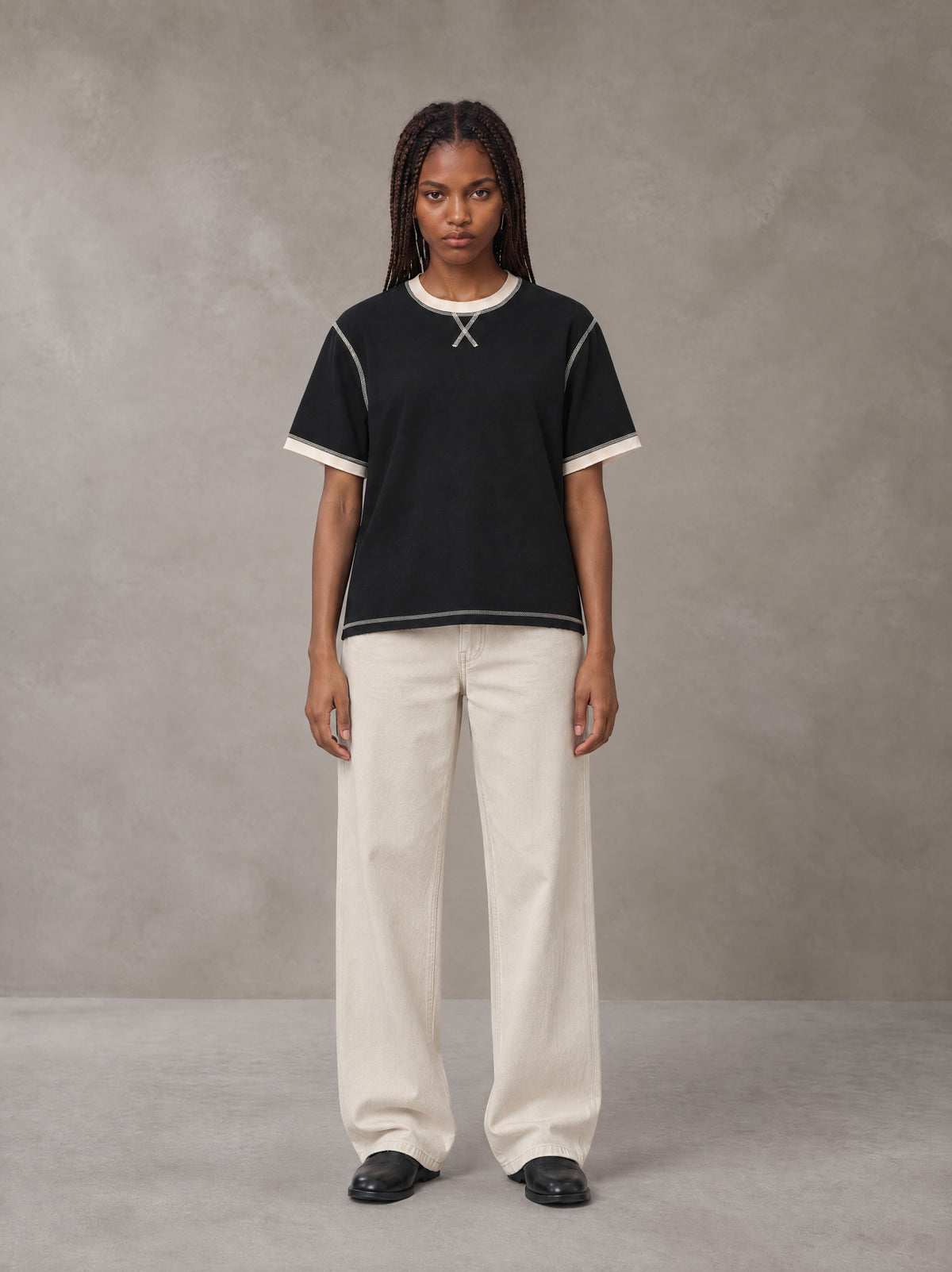Model wearing SM Sig. Contrast Stitch T-shirt in Midnight Black, front view.