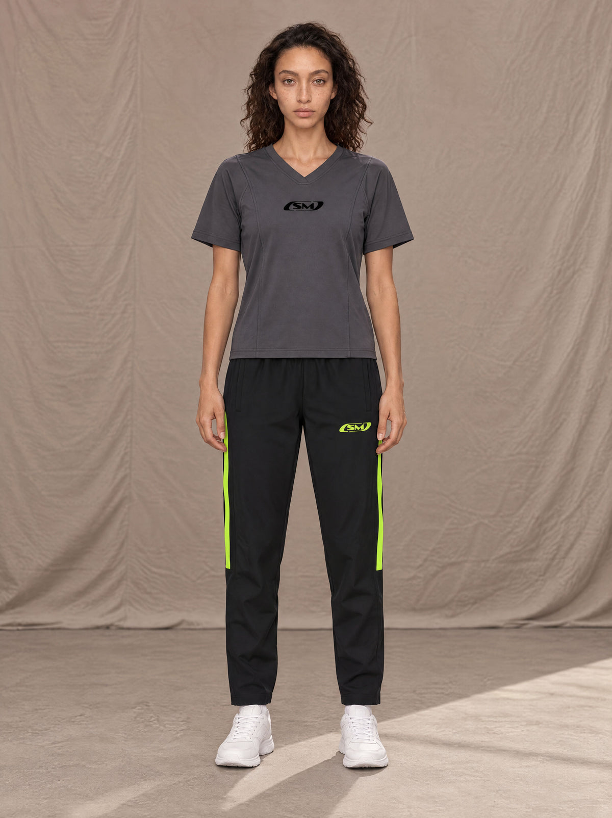 Model wearing SM Motion Stripe Track Trousers in Midnight Black, front view.