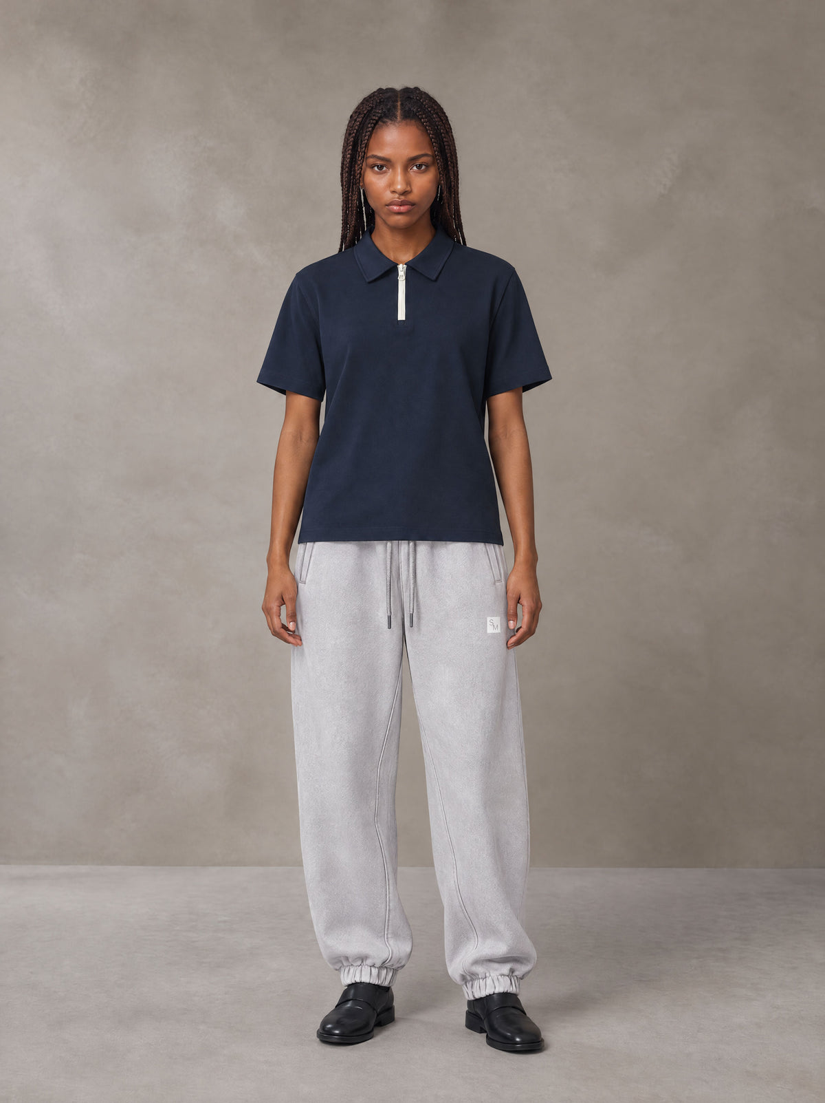 Model wearing SM Sig. Jogger Sweatpants in Floral Grey, front view.