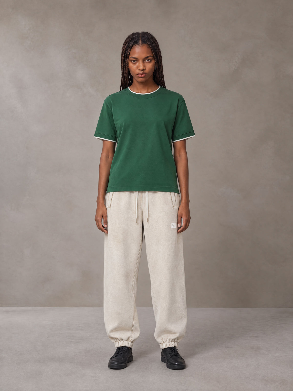 Model wearing SM Sig. Jogger Sweatpants in Oat Grey, front view.