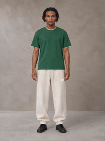 Model wearing SM Sig. Jogger Sweatpants in Oat Grey, front view.