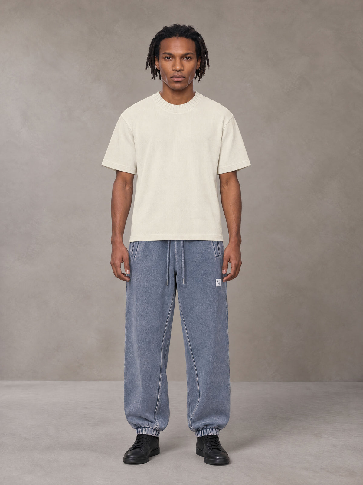 Model wearing SM Sig. Jogger Sweatpants in Washed Blue Jean, front view.