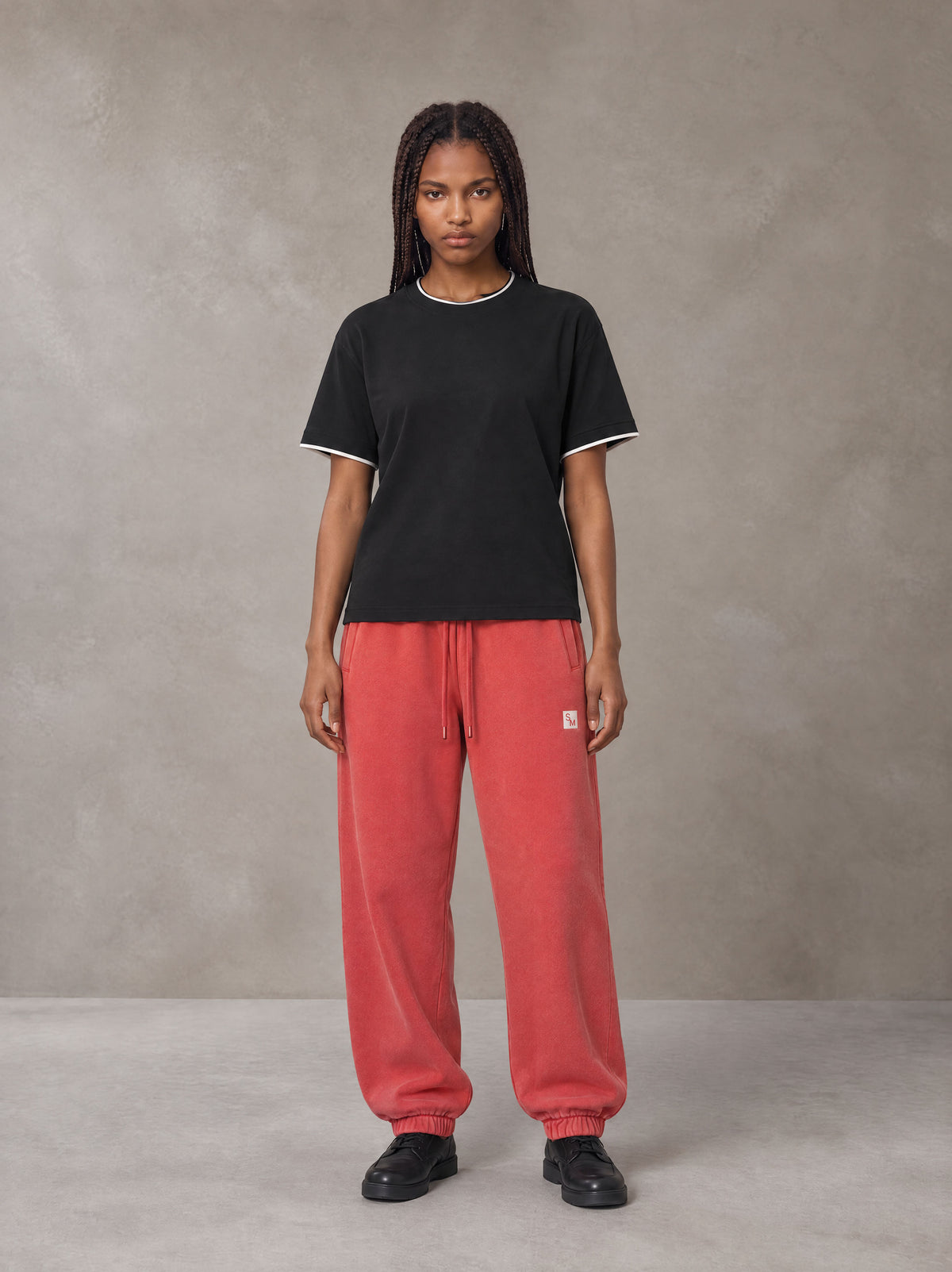 Model wearing SM Sig. Jogger Sweatpants in Watermelon Tint, front view.