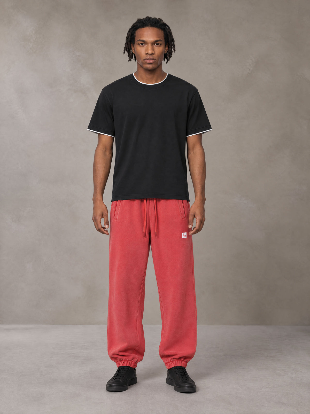 Model wearing SM Sig. Jogger Sweatpants in Watermelon Tint, front view.