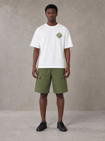Model wearing SM Verdant Fleur T-shirt in Lucent White, front view.