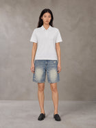 Model wearing SM Heritage Distressed Denim Shorts in Cadet Grey, front view.