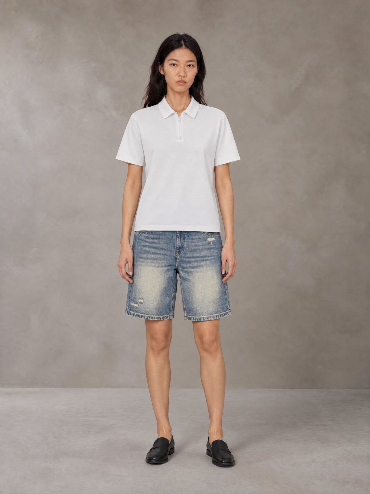 Model wearing SM Heritage Distressed Denim Shorts in Cadet Grey, front view.