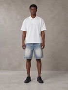 Model wearing SM Heritage Distressed Denim Shorts in Cadet Grey, front view.