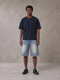 Model wearing SM Sunwash T-shirt in Oxford Navy, front view.