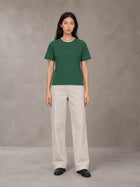 Model wearing SM Sunwash T-shirt in Dark Spring Green, front view.