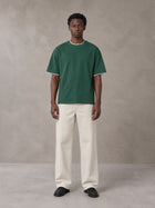 Model wearing SM Sunwash T-shirt in Dark Spring Green, front view.