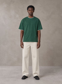 Model wearing SM Sunwash T-shirt in Dark Spring Green, front view.