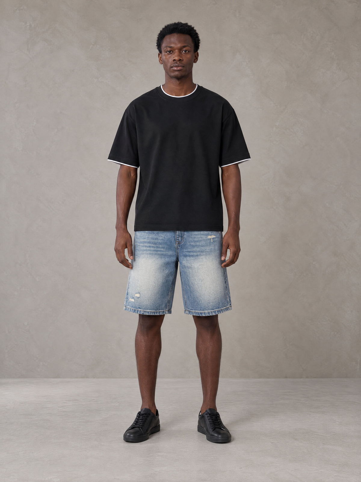 Model wearing SM Sunwash T-shirt in Midnight Black, front view.