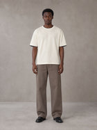 Model wearing SM Sunwash T-shirt in Oat Grey, front view.
