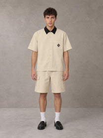 Model wearing SM Eternal Fleur Shirt in Pavlova with SM Eternal Fleur Utility Shorts in Pavlova, front view.