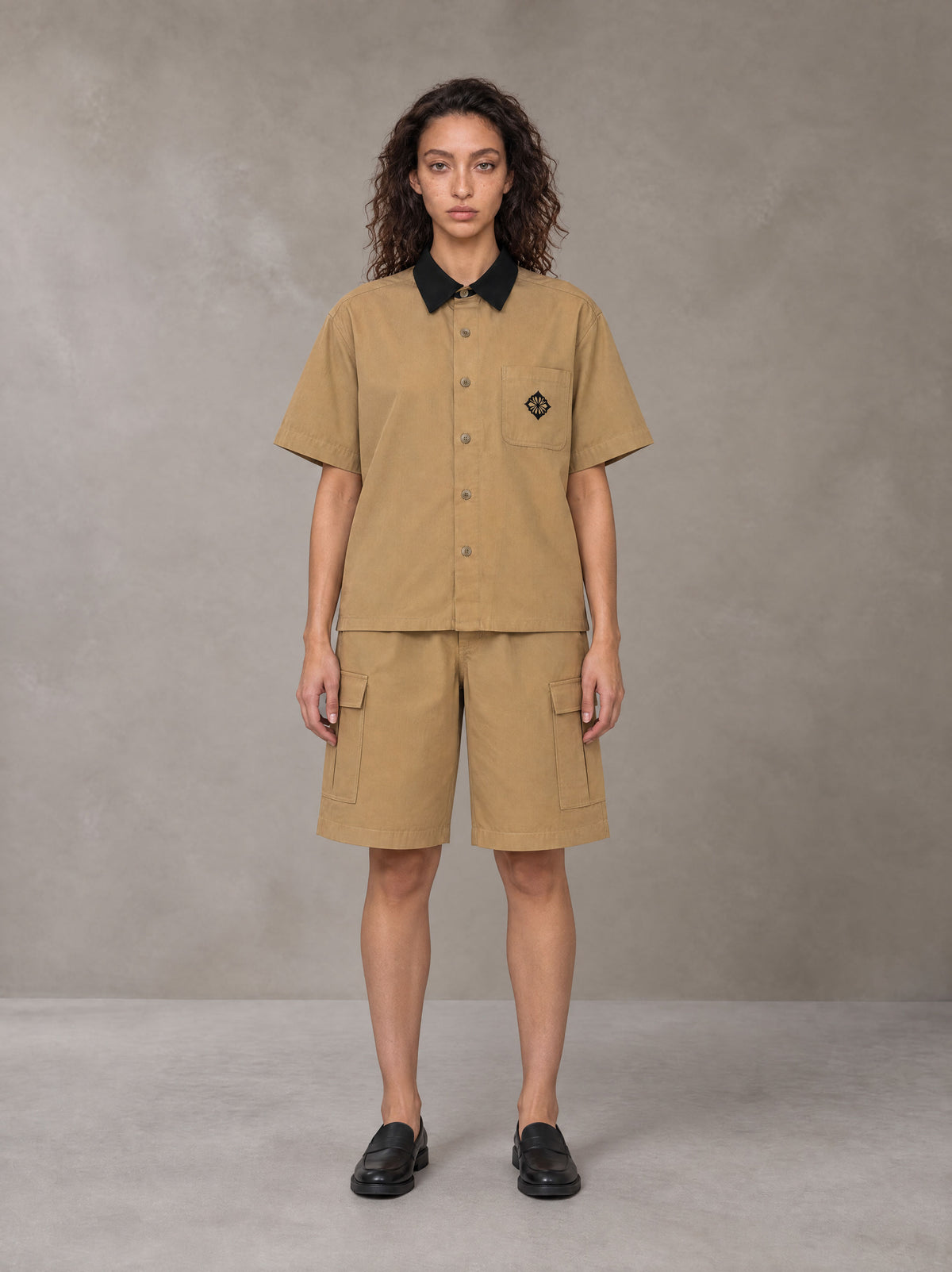 Model wearing SM Eternal Fleur Shirt in Camel Tan with SM Eternal Fleur Utility Shorts in Camel Tan, front view.