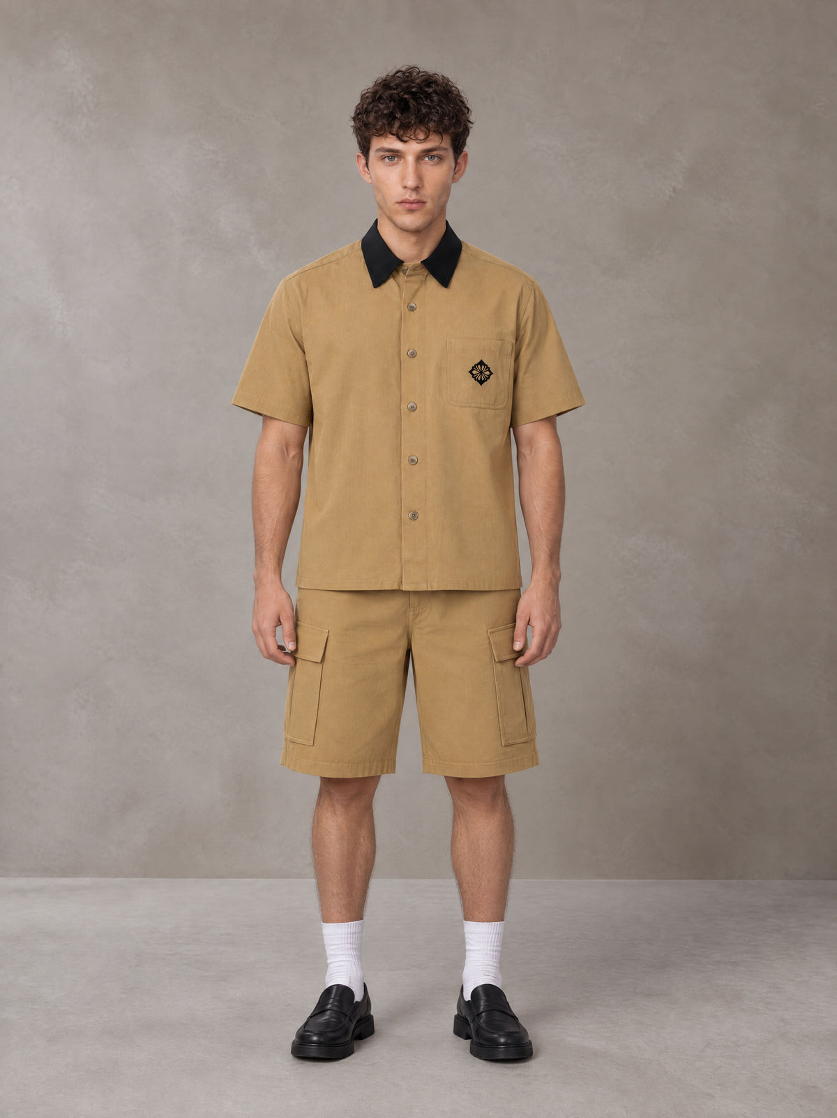Model wearing SM Eternal Fleur Shirt in Camel Tan with SM Eternal Fleur Utility Shorts in Camel Tan, front view.
