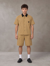 Model wearing SM Eternal Fleur Shirt in Camel Tan with SM Eternal Fleur Utility Shorts in Camel Tan, front view.
