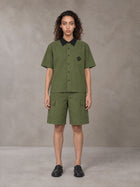 Model wearing SM Eternal Fleur Shirt in Camo Green with SM Eternal Fleur Utility Shorts in Camo Green, front view.