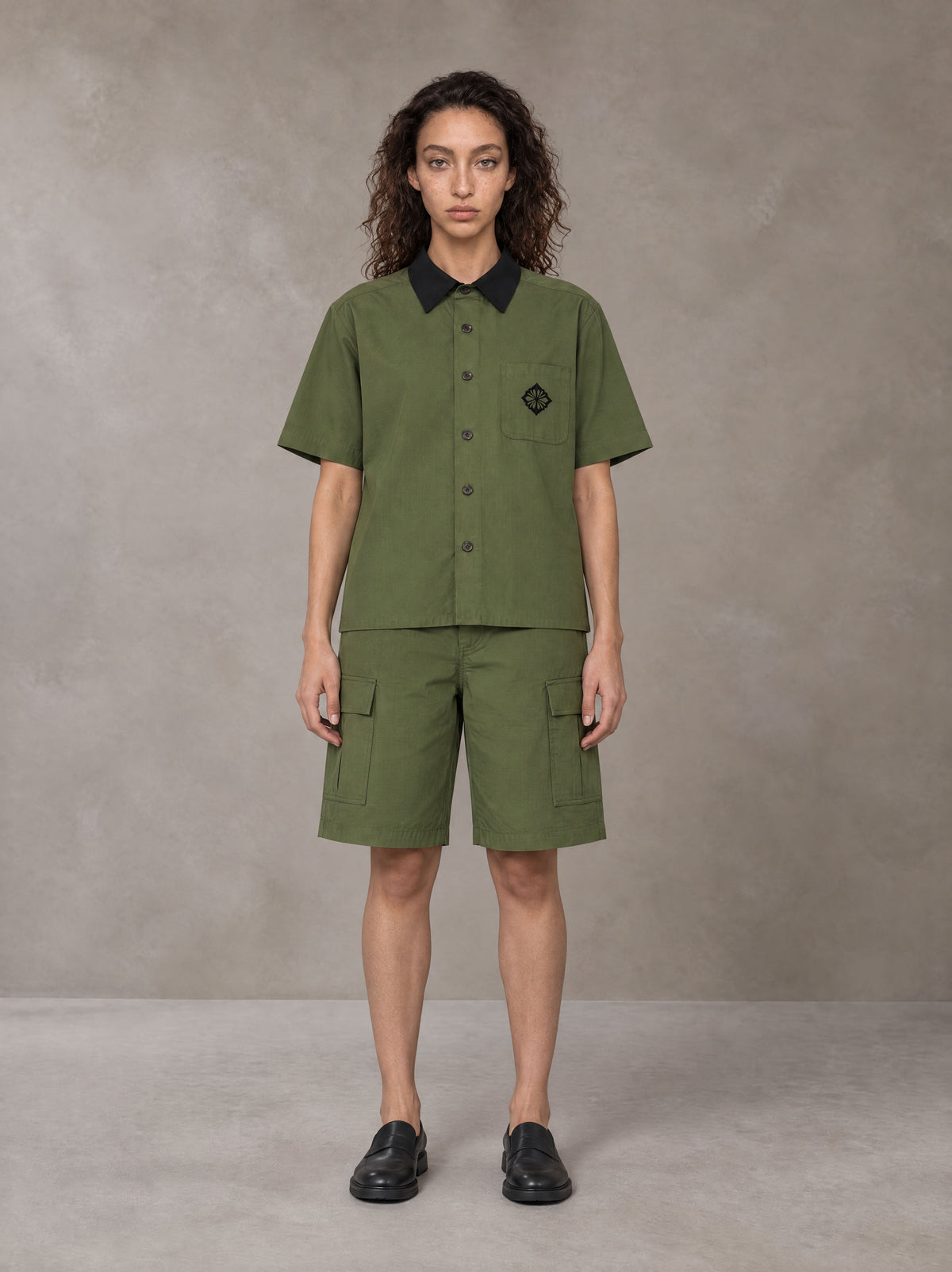 Model wearing SM Eternal Fleur Shirt in Camo Green with SM Eternal Fleur Utility Shorts in Camo Green, front view.