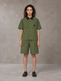 Model wearing SM Eternal Fleur Shirt in Camo Green with SM Eternal Fleur Utility Shorts in Camo Green, front view.