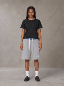 Model wearing SM Plaid Shorts in Floral Grey, front view.