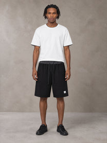Model wearing SM Plaid Shorts in Midnight Black, front view.
