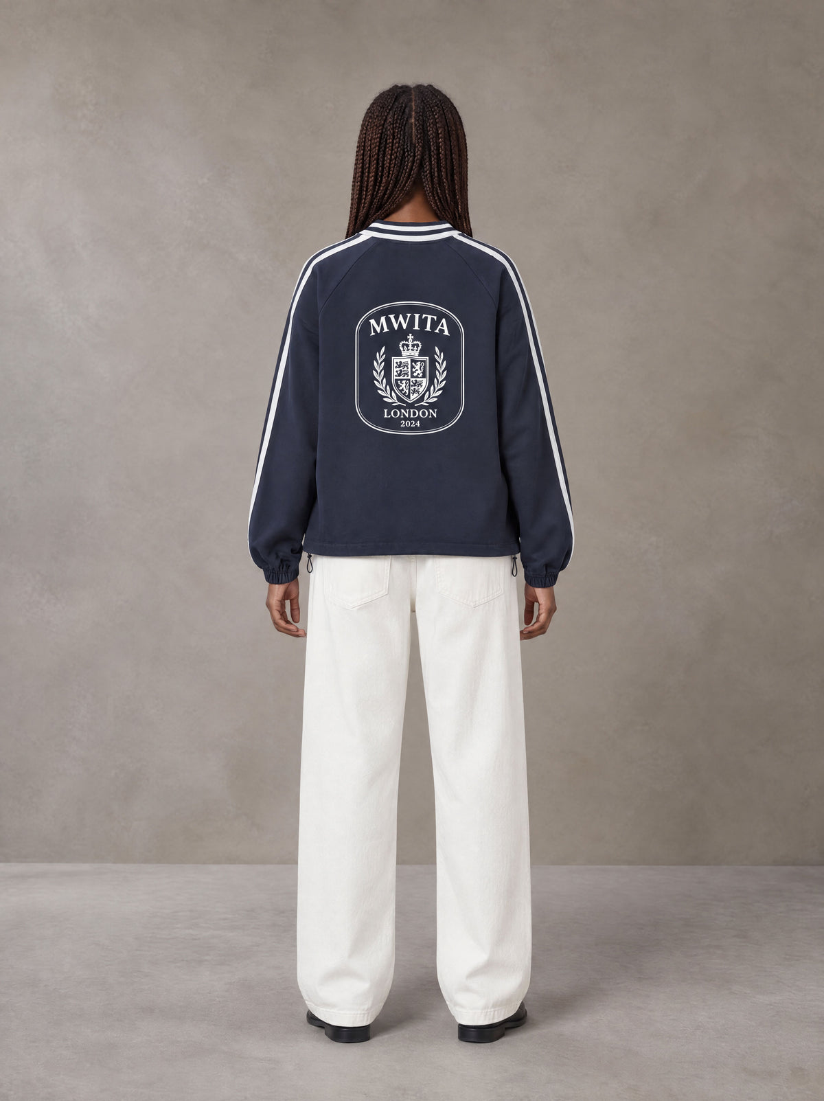 Model wearing SM Royal Emblem Panel Sweatshirt in Chambray, rear view.