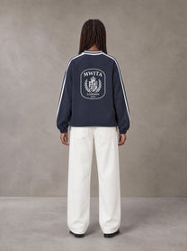 Model wearing SM Royal Emblem Panel Sweatshirt in Chambray, rear view.
