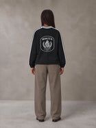 Model wearing SM Royal Emblem Panel Sweatshirt in Midnight Black, rear view.