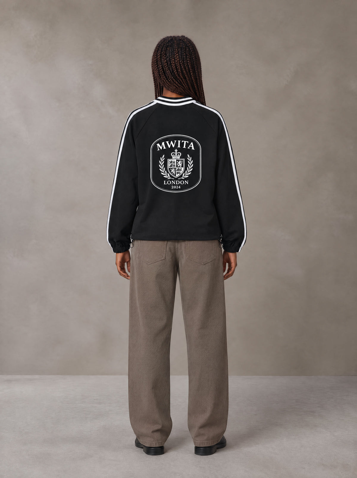 Model wearing SM Royal Emblem Panel Sweatshirt in Midnight Black, rear view.