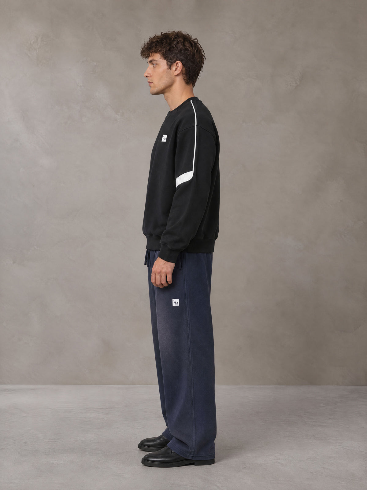 Model wearing SM Sig. Tempo Sweatshirt in Midnight Black, side view.