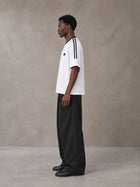 Model wearing SM Sig. Striped T-shirt in Lucent White, side view.