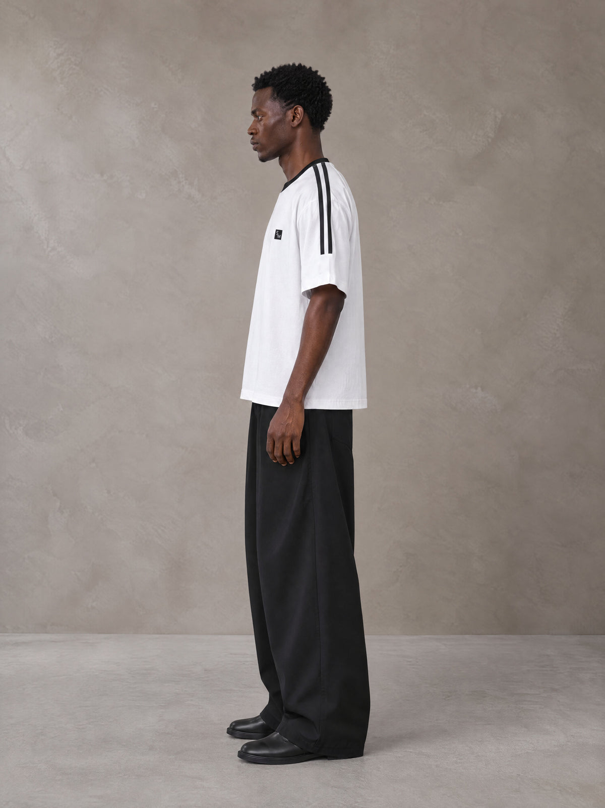 Model wearing SM Sig. Striped T-shirt in Lucent White, side view.