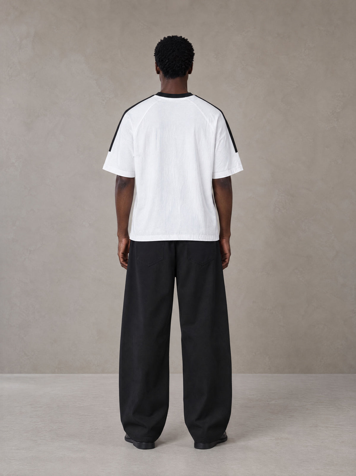 Model wearing SM Sig. Striped T-shirt in Lucent White, rear view.