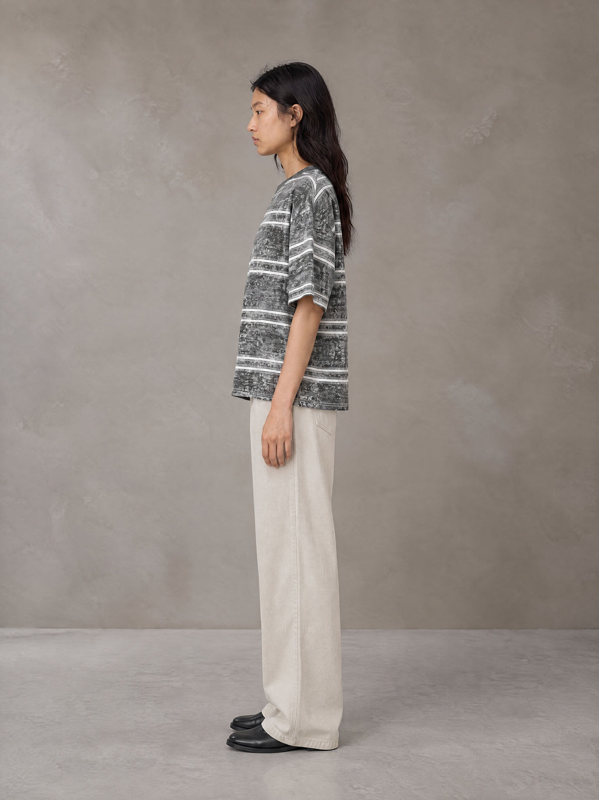 Model wearing SM Sig. Snow Washed Striped T-shirt in Pure Grey, side view.