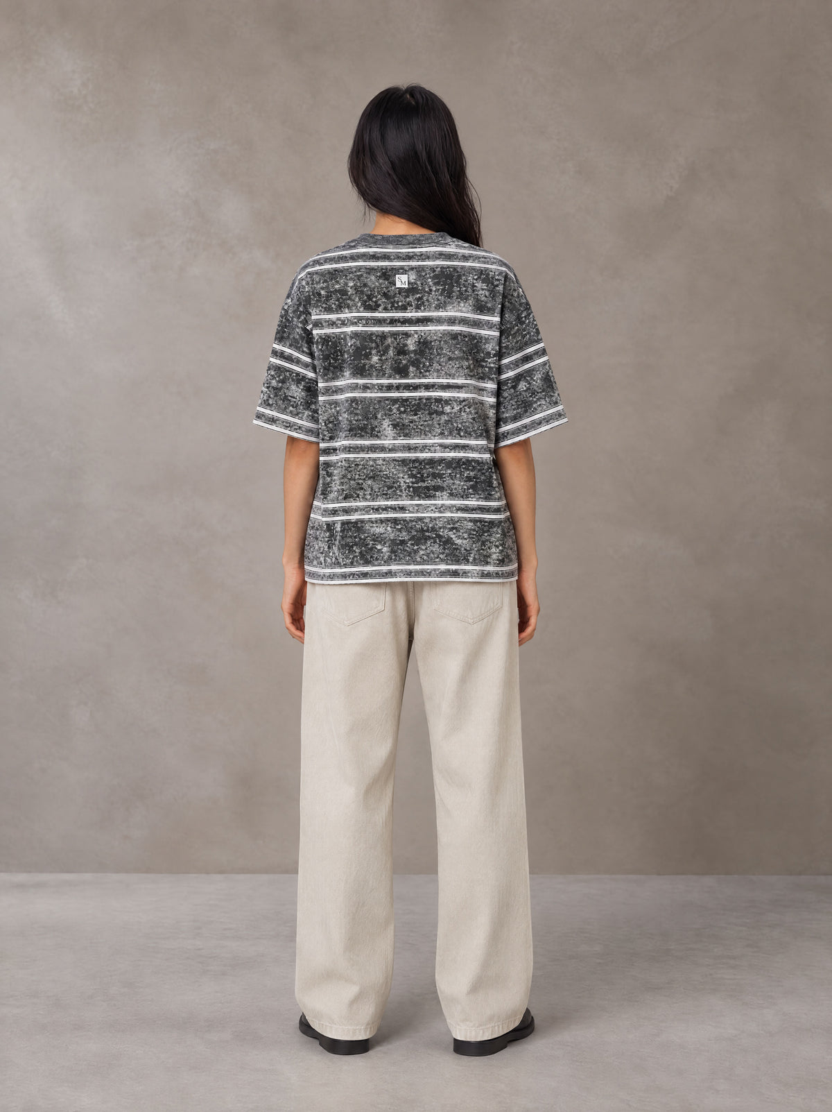 Model wearing SM Sig. Snow Washed Striped T-shirt in Pure Grey, rear view.