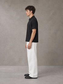 Model wearing SM Sig. Half-Zip Polo Shirt in Midnight Black, side view.