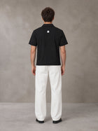 Model wearing SM Sig. Half-Zip Polo Shirt in Midnight Black, rear view.