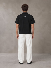 Model wearing SM Sig. Half-Zip Polo Shirt in Midnight Black, rear view.