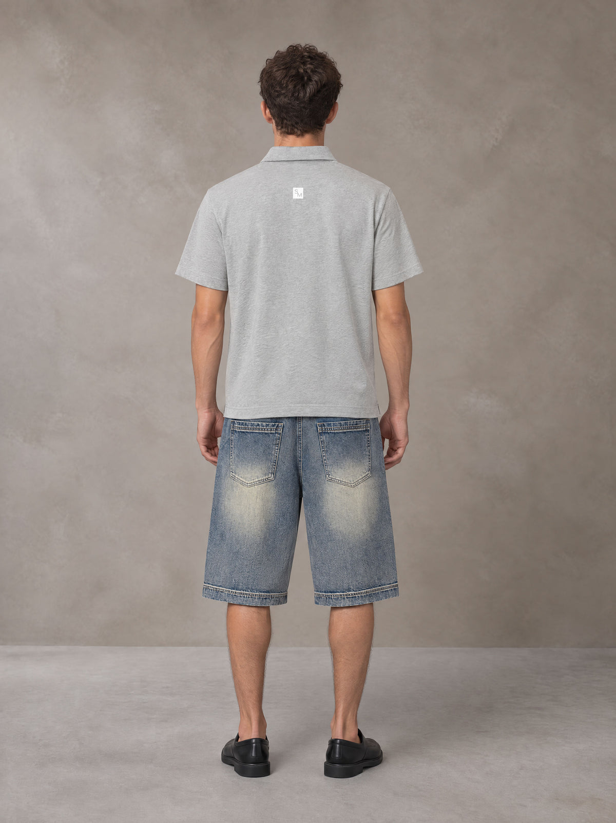 Model wearing SM Sig. Half-Zip Polo Shirt in Floral Grey, rear view.