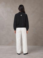 Model wearing SM Sig. Fleece Polo Sweatshirt in Midnight Black, rear view.