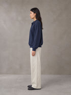 Model wearing SM Sig. Fleece Polo Sweatshirt in Oxford Navy, side view.