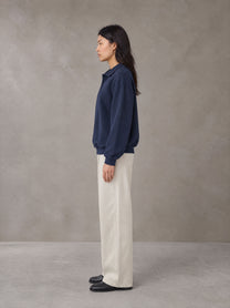 Model wearing SM Sig. Fleece Polo Sweatshirt in Oxford Navy, side view.