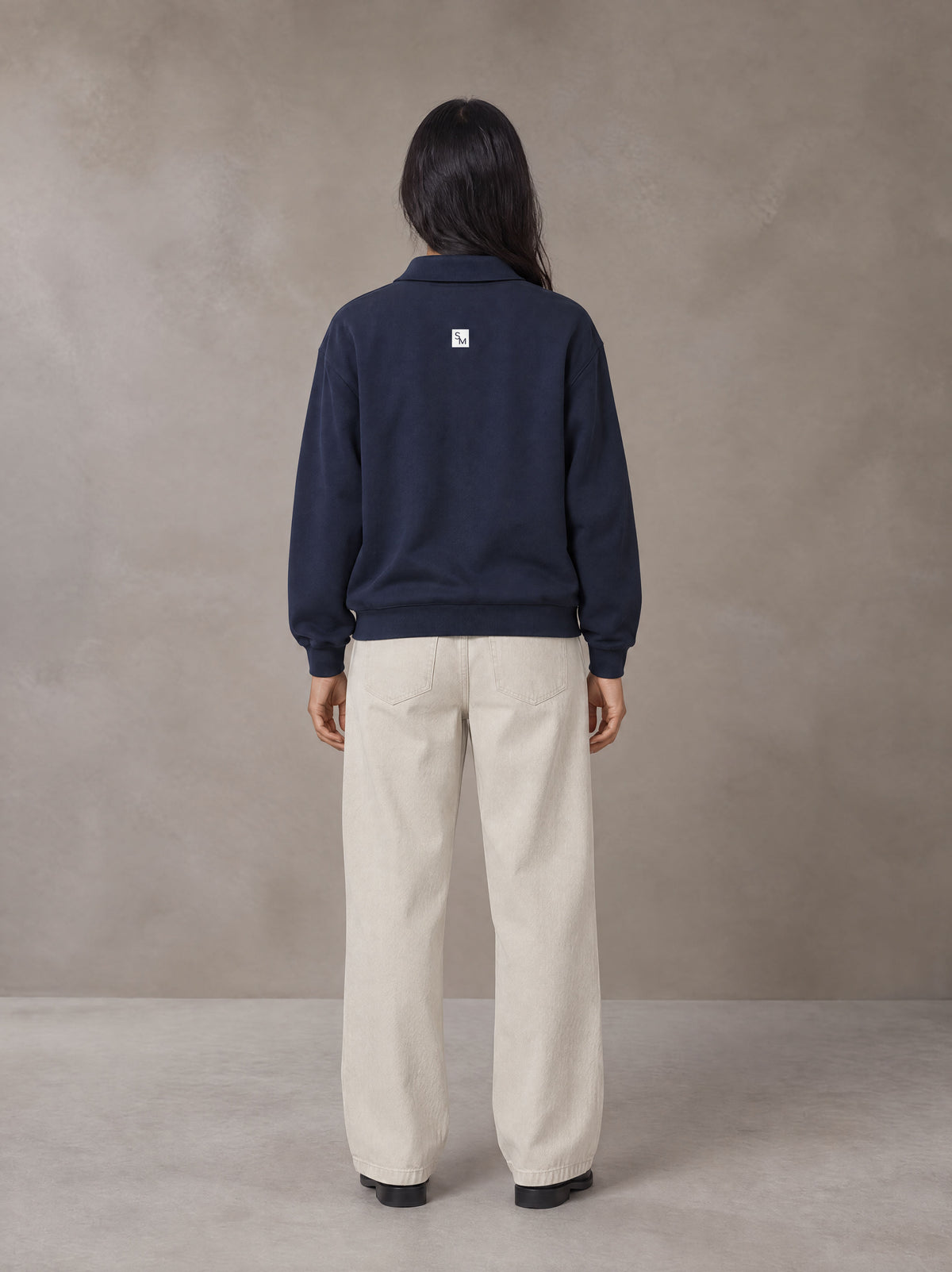 Model wearing SM Sig. Fleece Polo Sweatshirt in Oxford Navy, rear view.