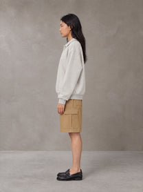 Model wearing SM Sig. Fleece Polo Sweatshirt in Oat Grey, side view.