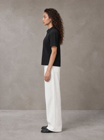 Model wearing SM Straight Leg Trousers in Lucent White, side view.